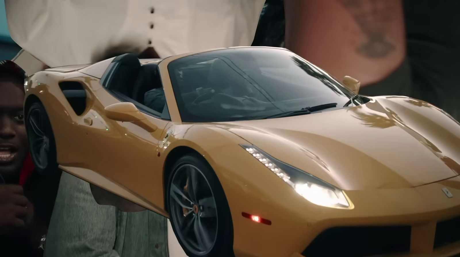 a man standing next to a yellow sports car