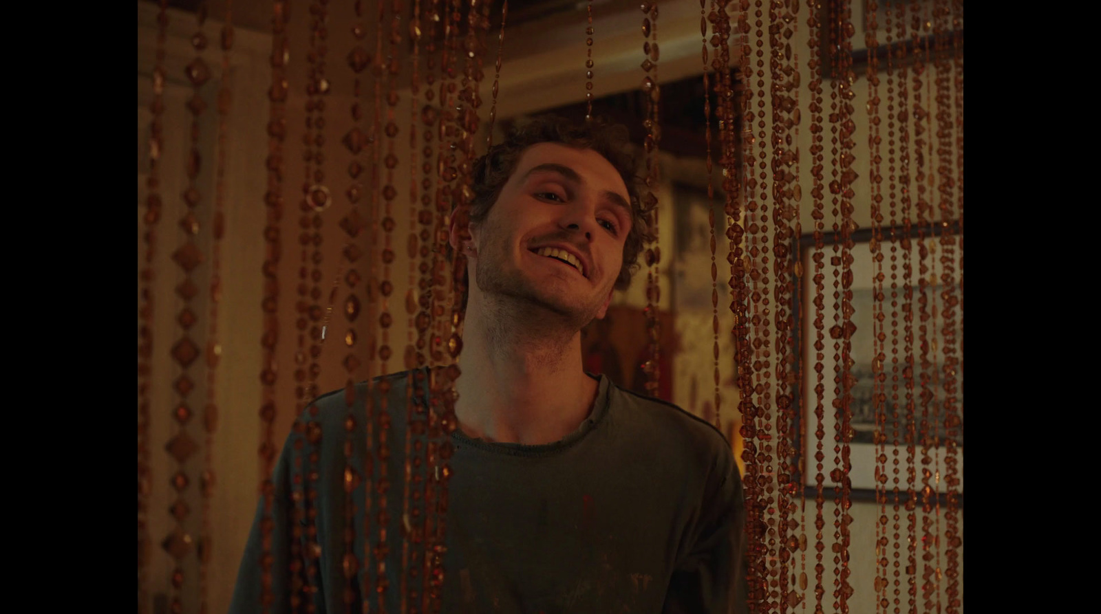 a man standing in front of a window covered in beads