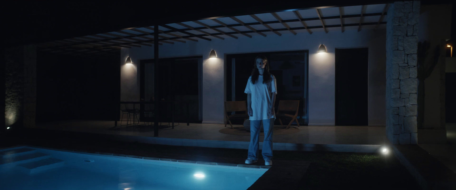 a man standing in front of a pool at night