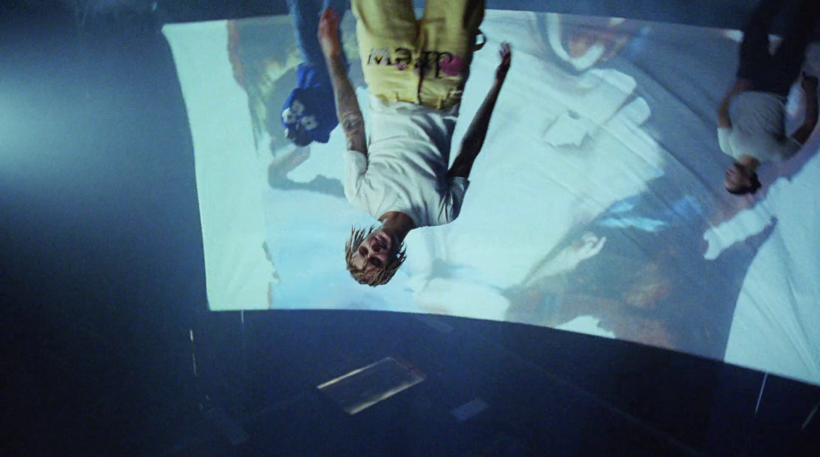 a man is upside down on a large screen