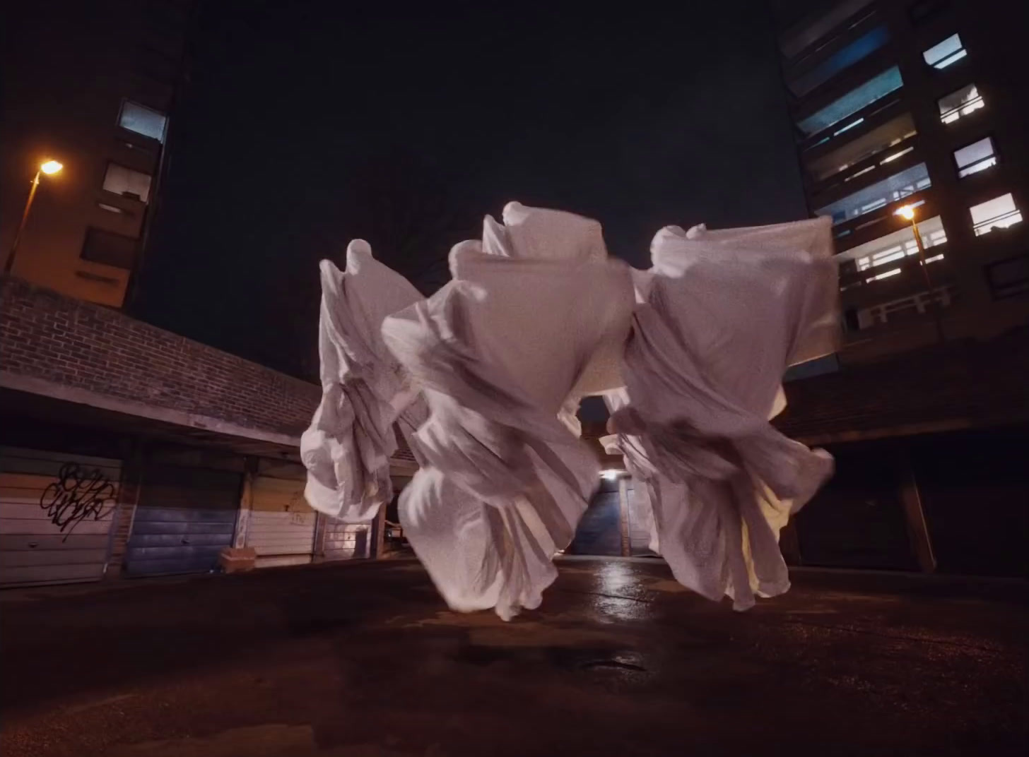 a group of white cloths hanging from the side of a building