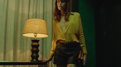 a woman standing next to a lamp in a room