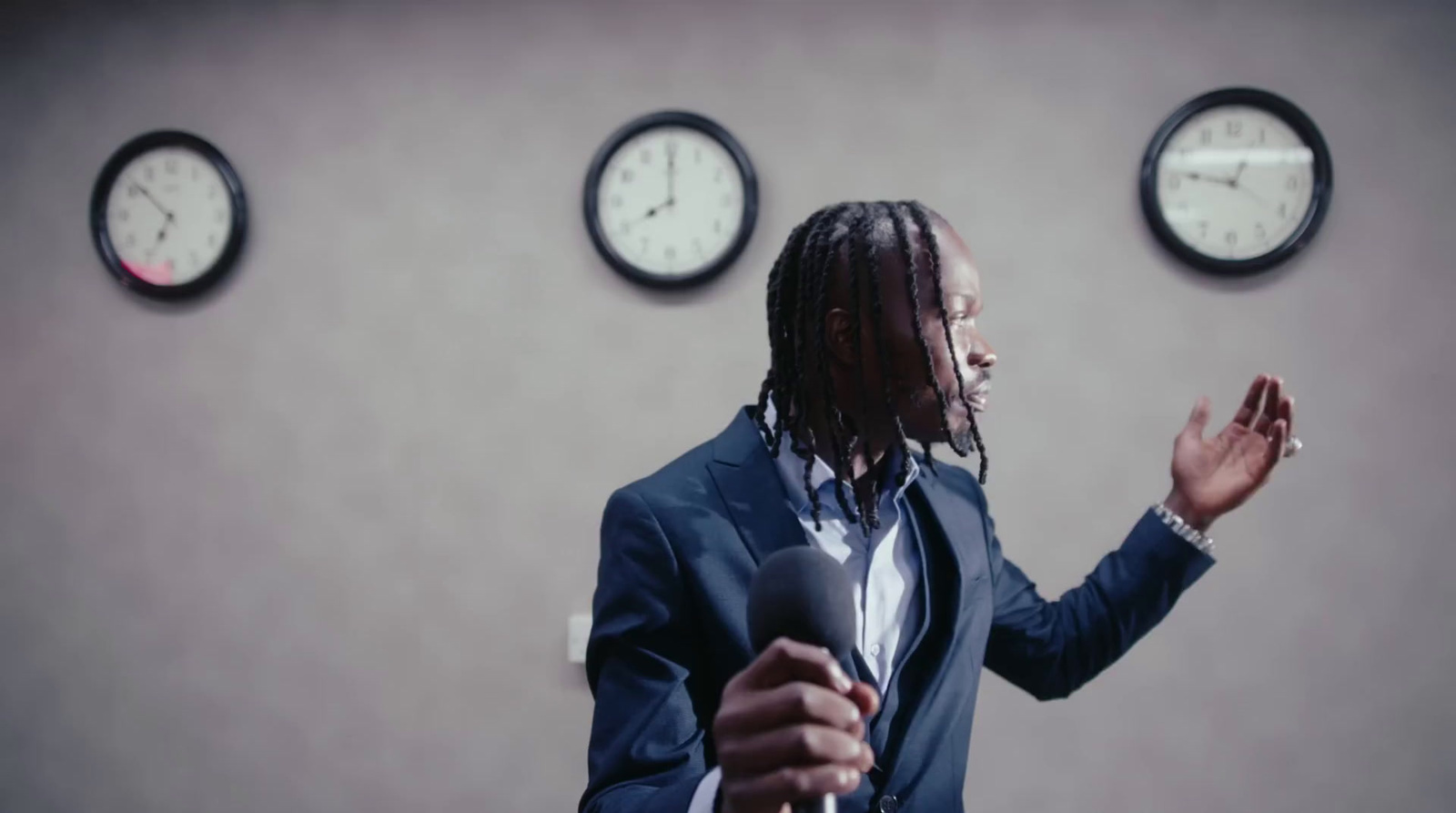 a man standing in front of three clocks