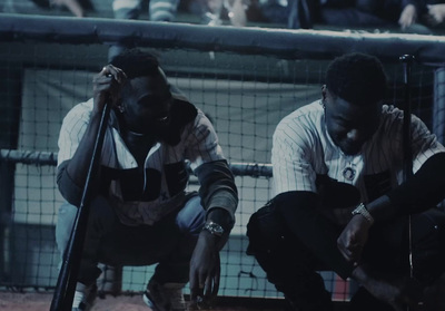 a couple of men sitting on top of a baseball field