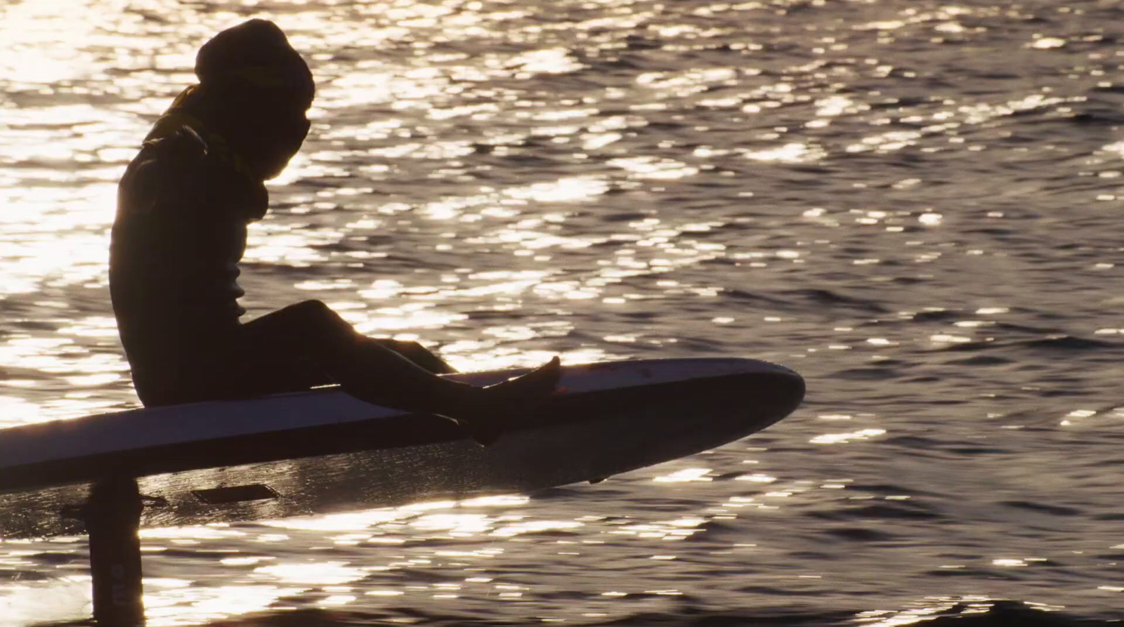 a person sitting on a surfboard in the water