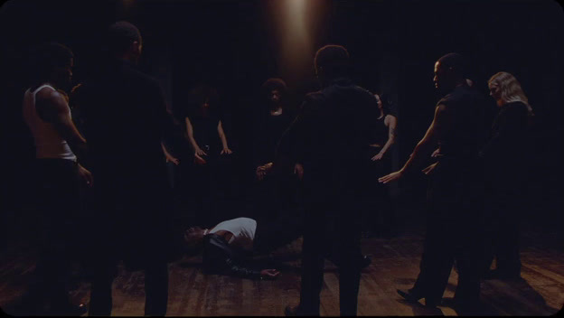 a group of people standing around a person laying on the floor