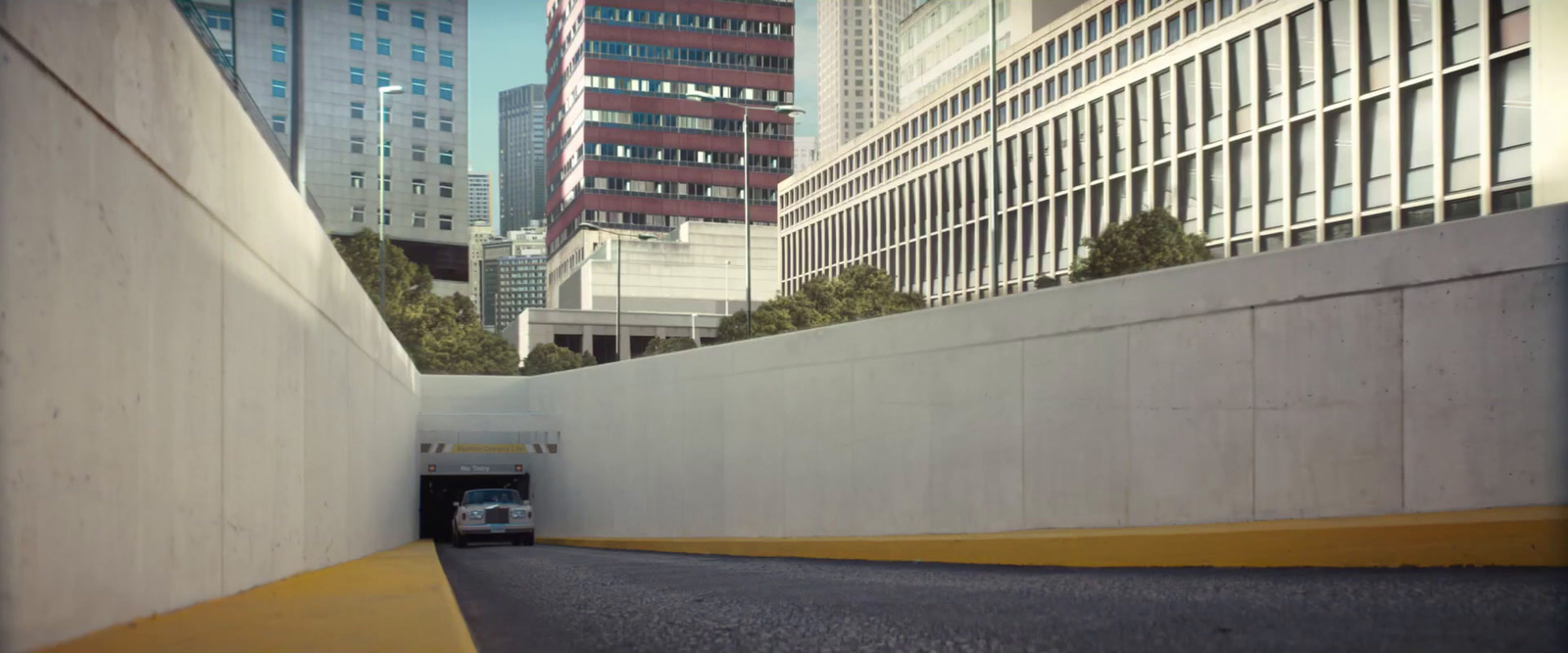 a car driving down a street next to tall buildings