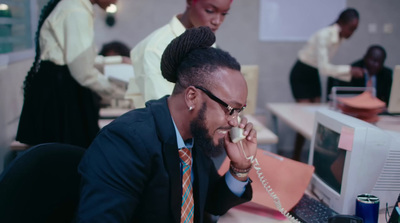 a man sitting at a desk talking on a phone