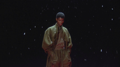 a man in a raincoat standing in the rain