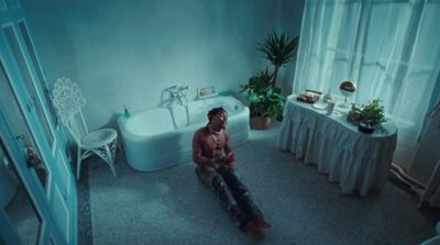 a man sitting on the floor of a bathroom