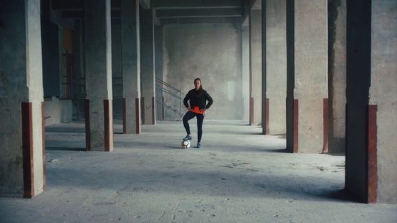 a man in a black jacket is walking down a hallway