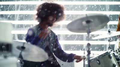 a man playing drums in front of a window