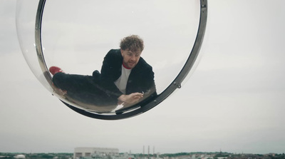 a man sitting on a circular object in the air