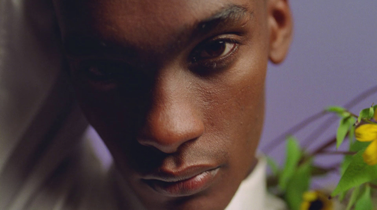 a close up of a person wearing a suit and tie