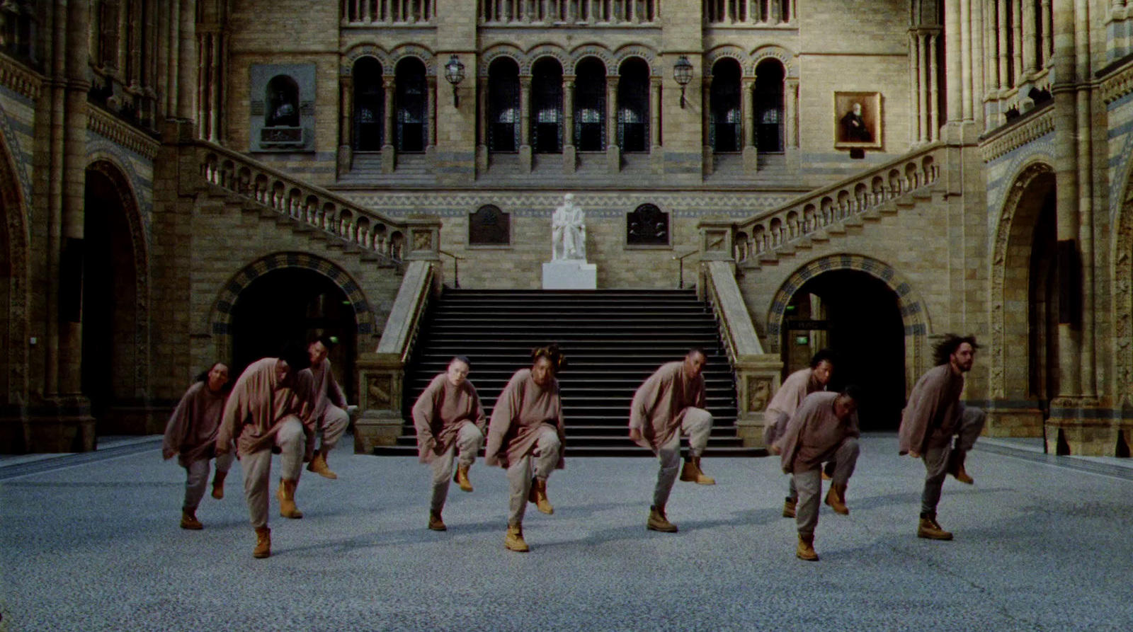 a group of men walking down a street in front of a building