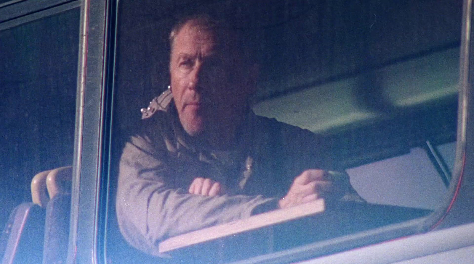 a man sitting in a bus looking out the window