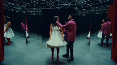 a man and a woman standing in front of a mirror