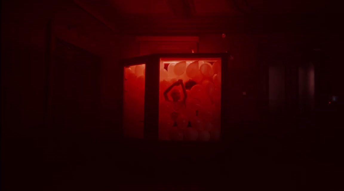 a dark room with a red light coming through the door