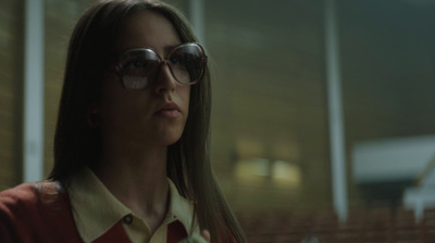 a woman wearing sunglasses standing in front of a building