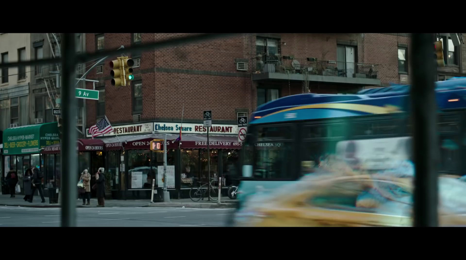 a bus driving down a street next to tall buildings