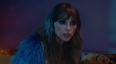 a woman in a fur coat sitting on a couch