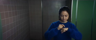 a woman standing in a bathroom holding a piece of food