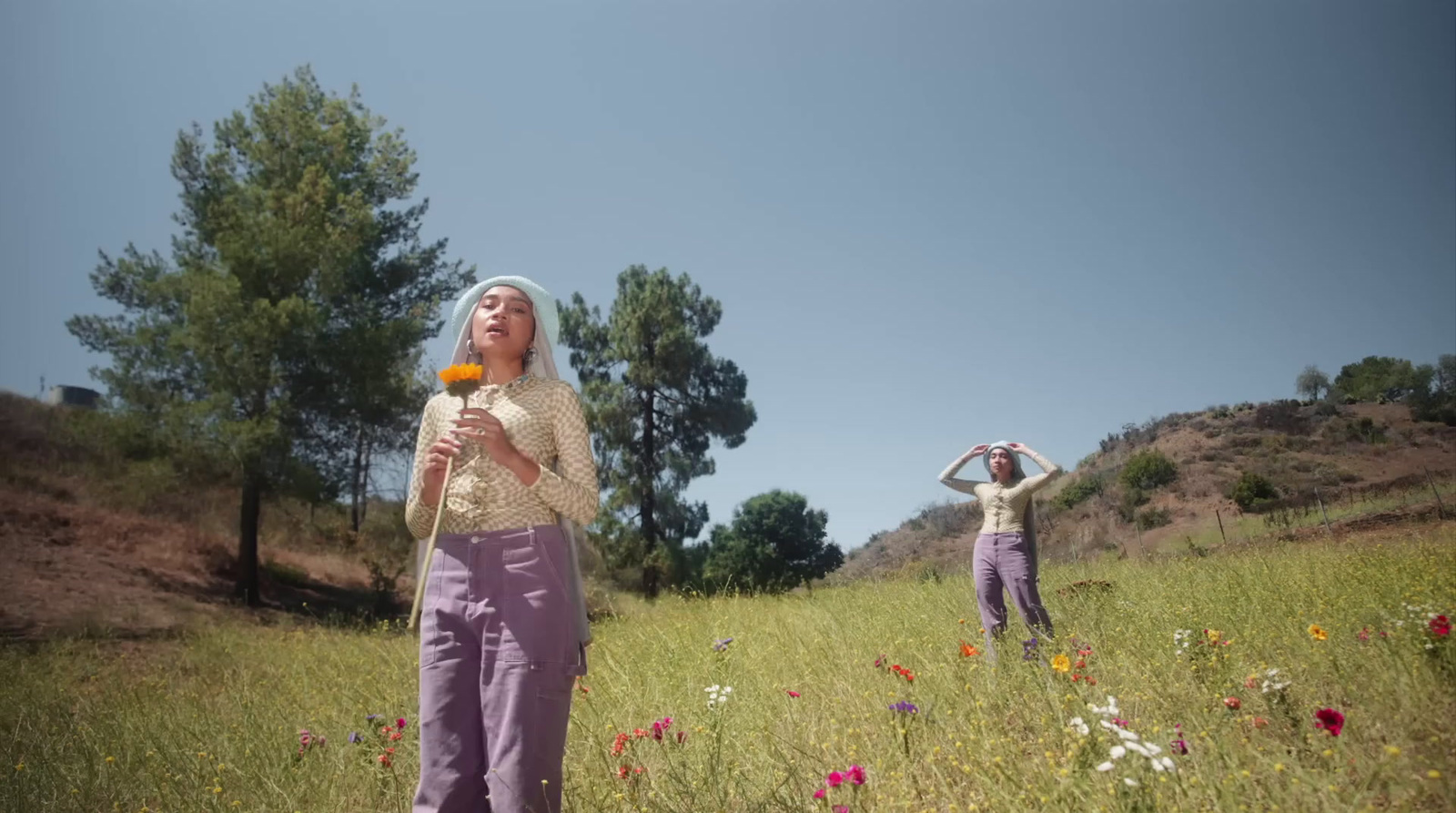 two women standing in a field of flowers