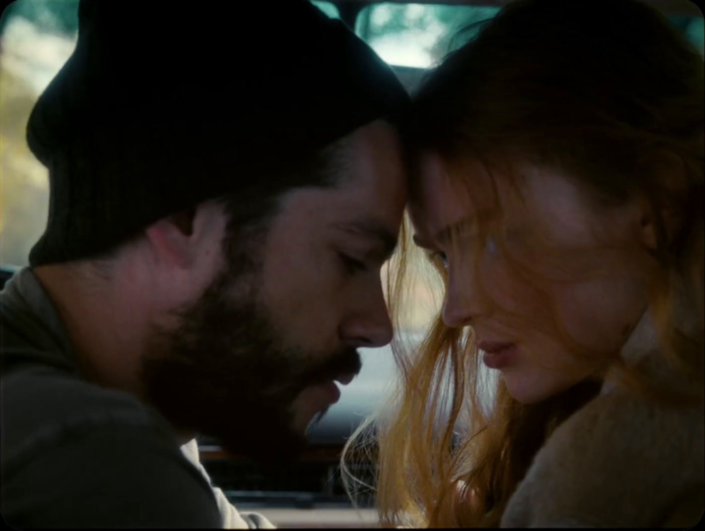 a man and a woman in a car looking at each other