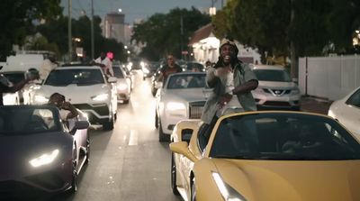 a group of cars driving down a street next to each other