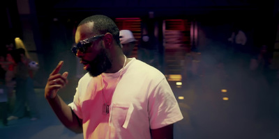 a man in a pink shirt and sunglasses standing in front of a group of people