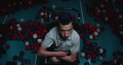 a man sitting in a chair surrounded by balls