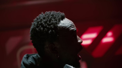 a man in a dark room with a red light behind him