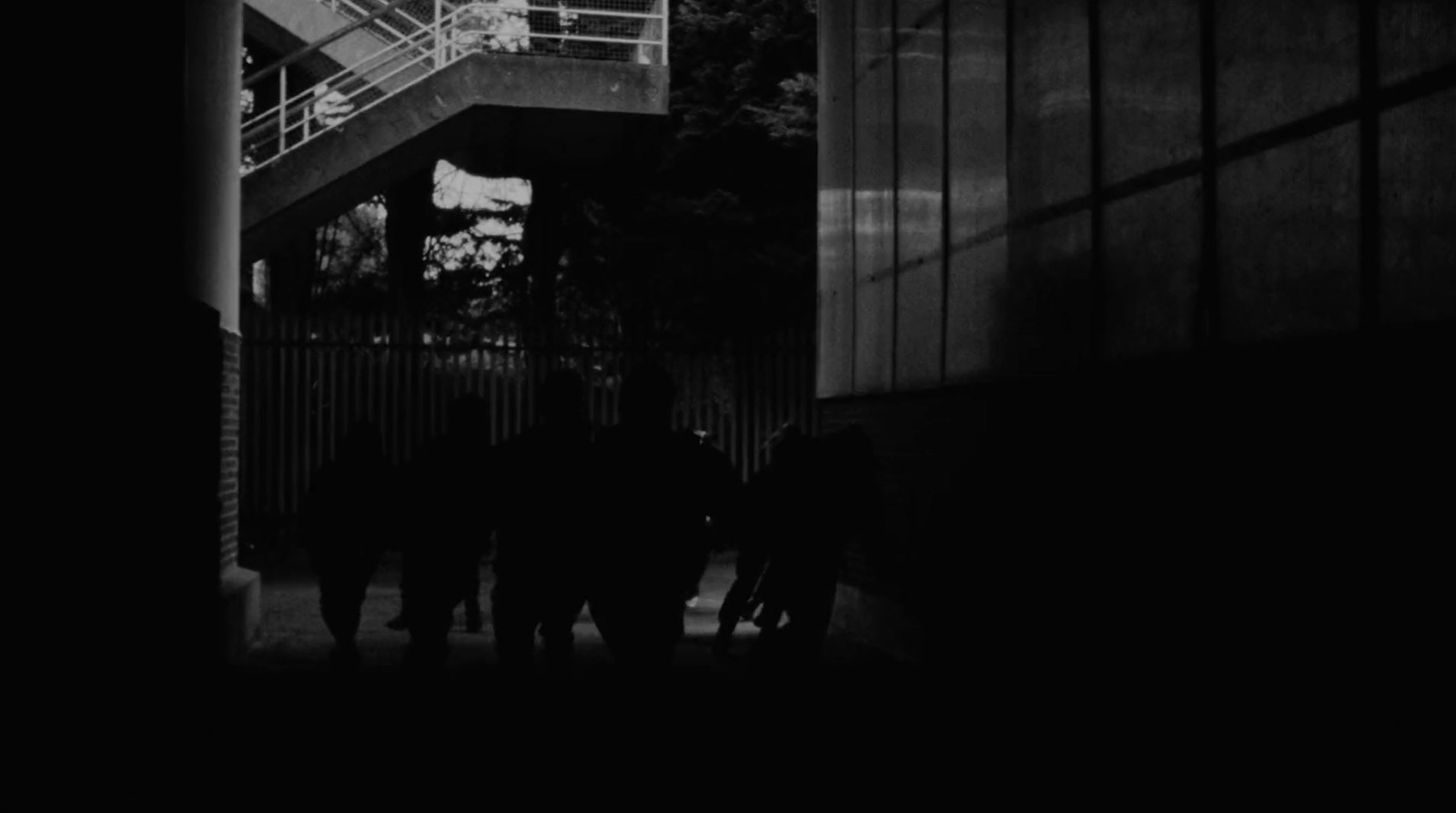 a group of people walking down a street next to a tall building