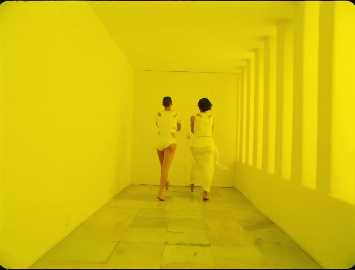 a couple of women walking down a hallway next to each other