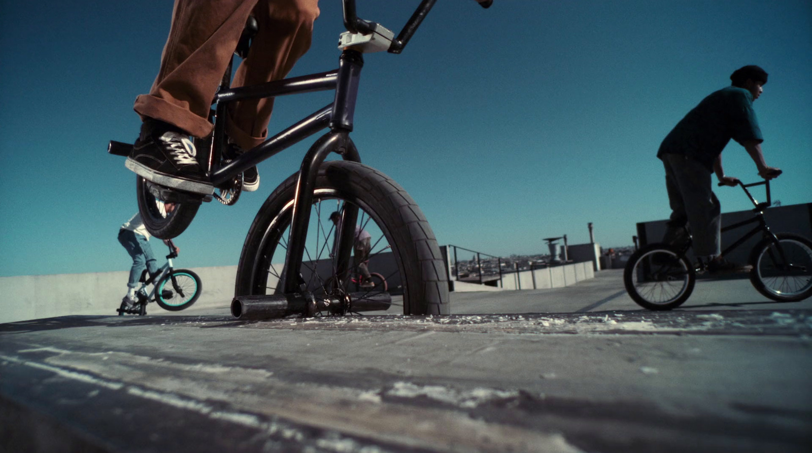 a man riding a bike next to another man on a skateboard