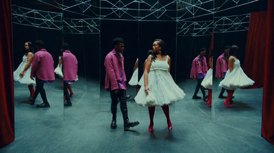 a woman in a white dress standing in front of a mirror