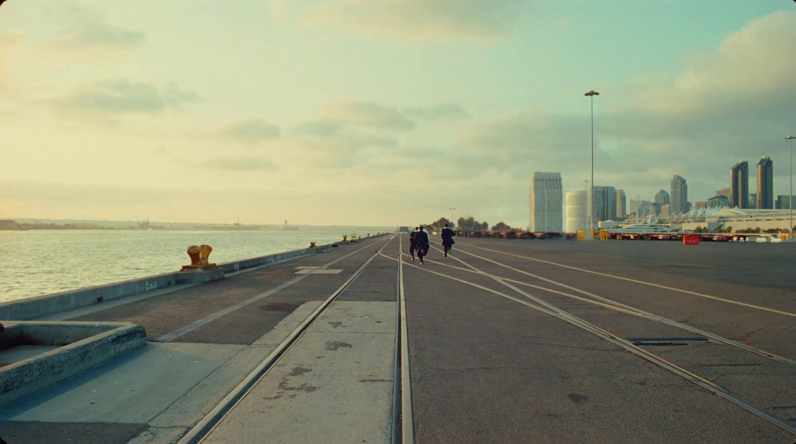 a couple of people walking across a bridge over water