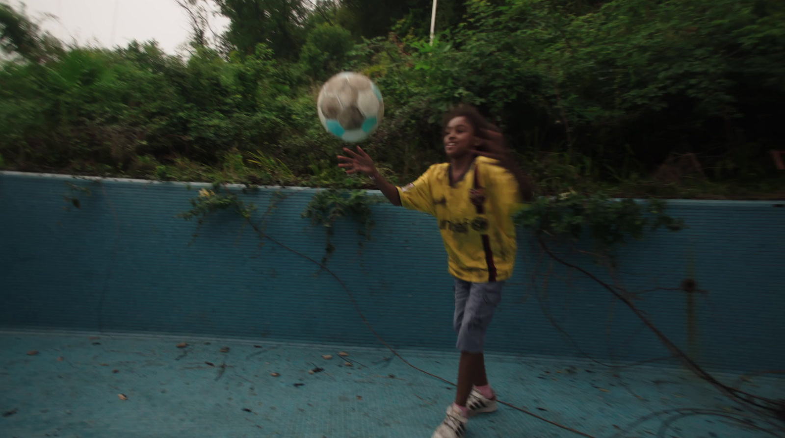 a young girl is playing with a soccer ball