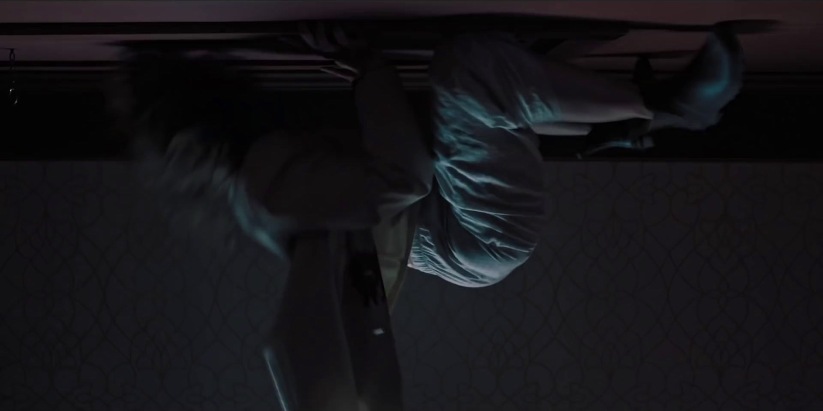 a person hanging upside down in a dark room