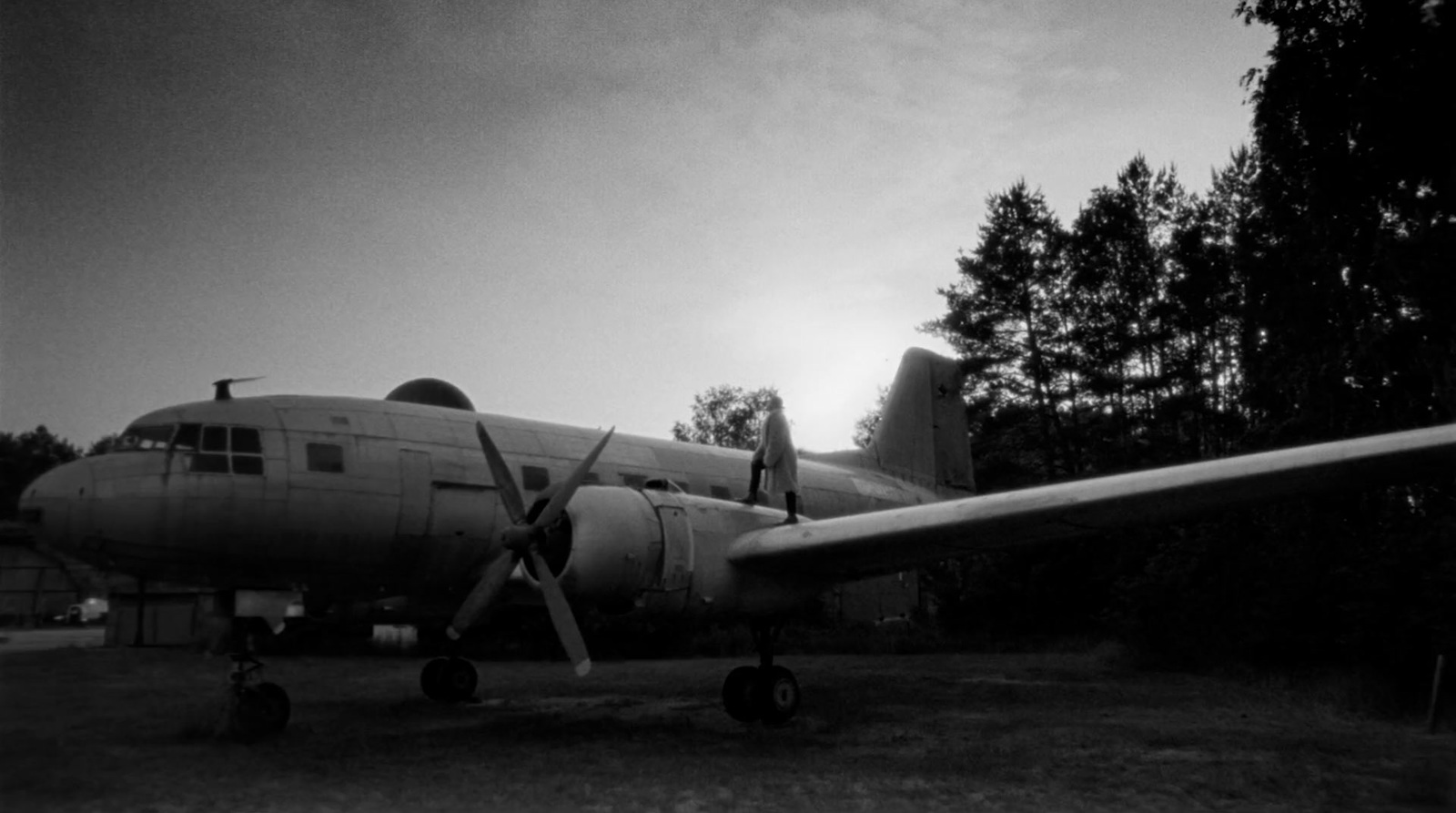 a large propeller plane parked on top of a grass covered field