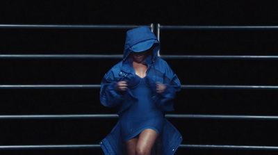 a woman in a blue raincoat is walking down stairs