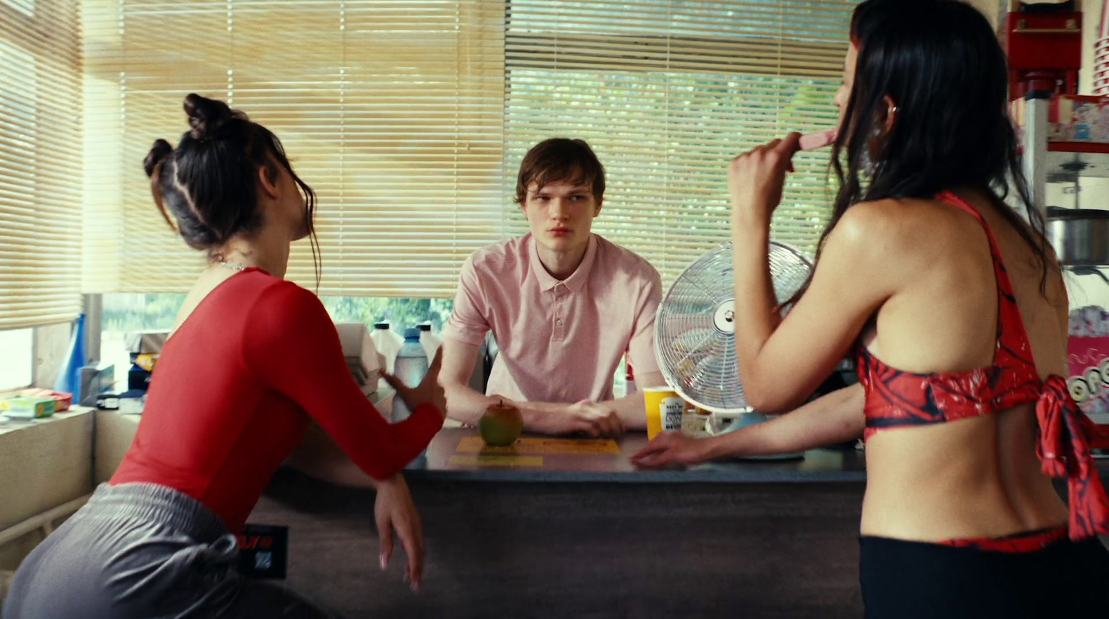 a woman sitting at a counter talking to a man