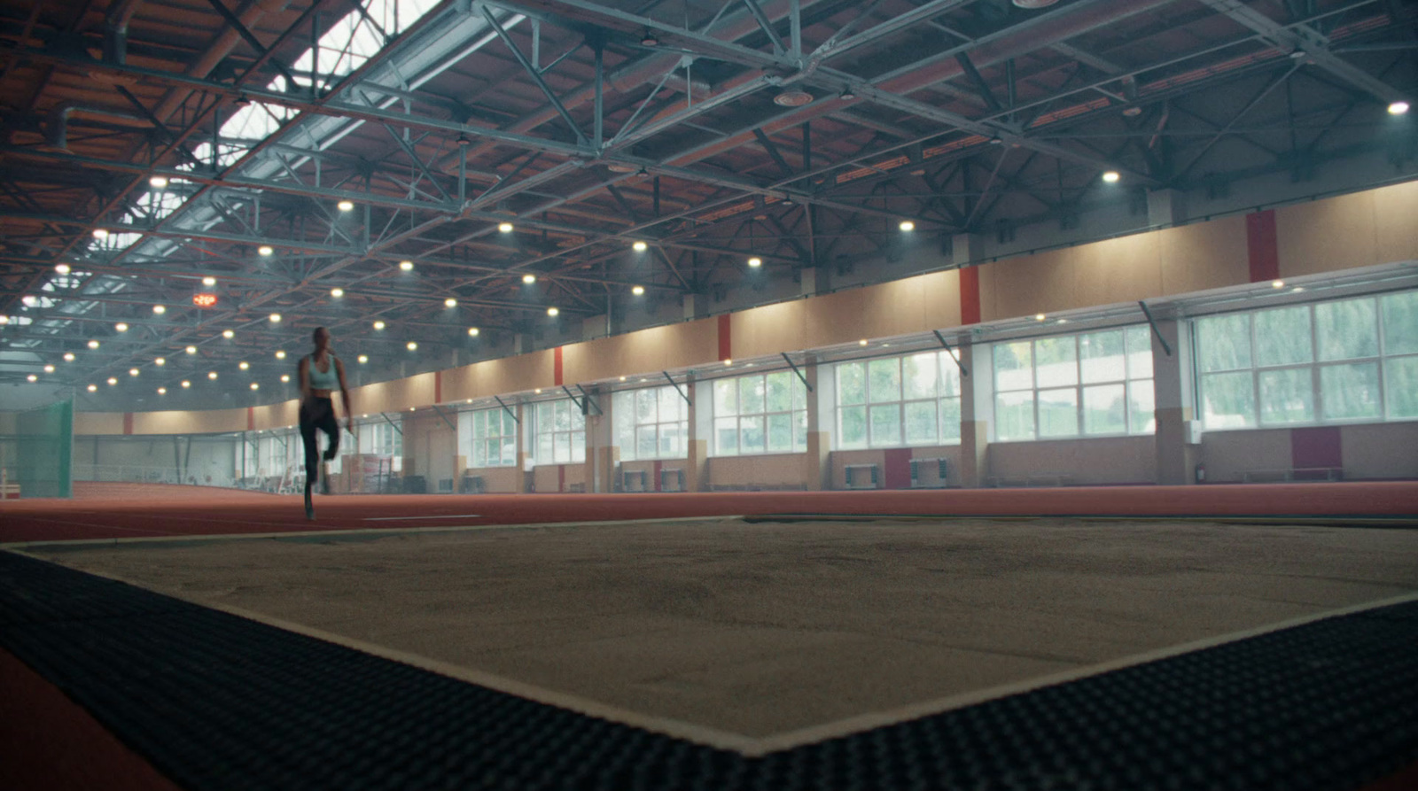 a person standing on a tennis court in a building