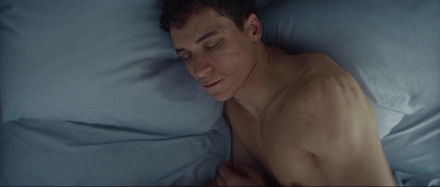 a man laying in bed with his eyes closed