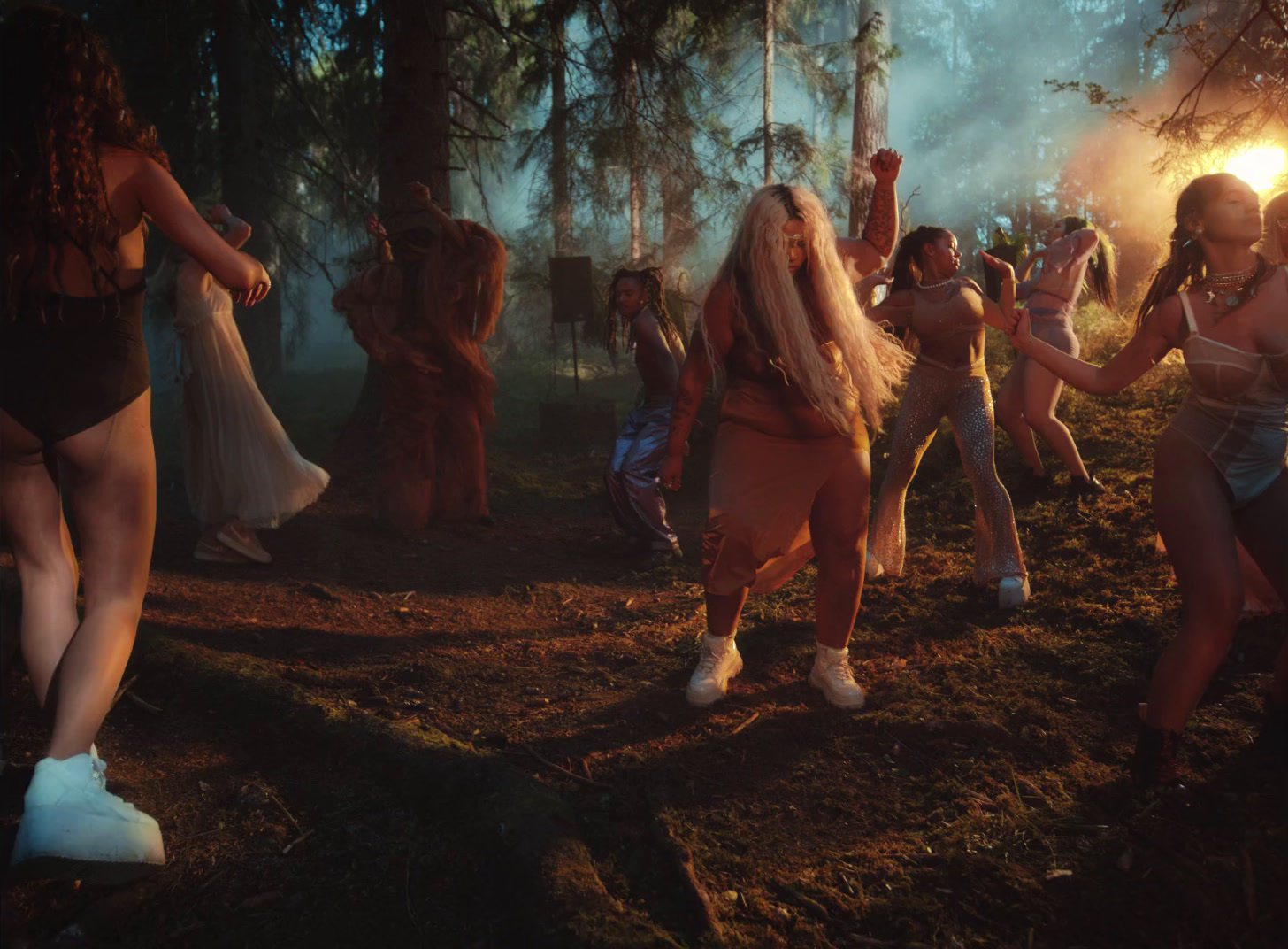 a group of women dancing in the woods