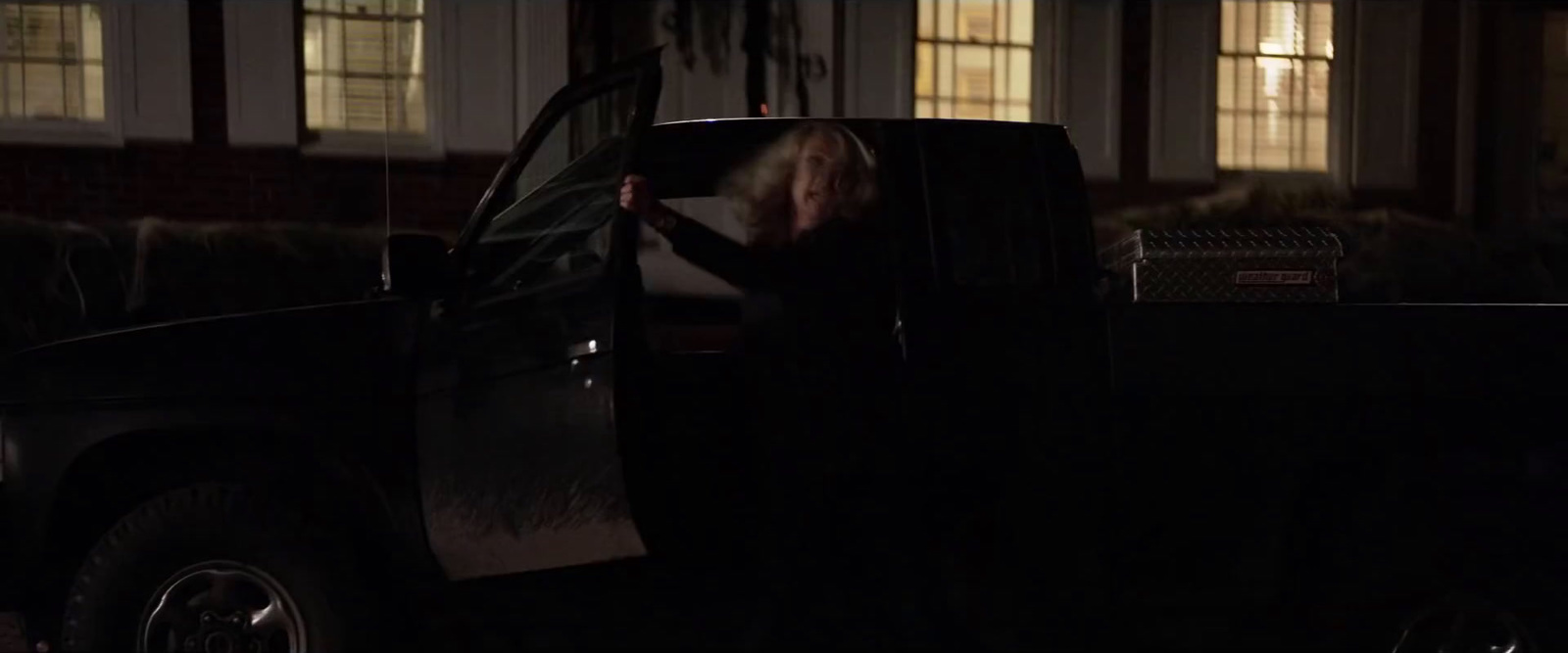 a woman standing in the back of a pick up truck