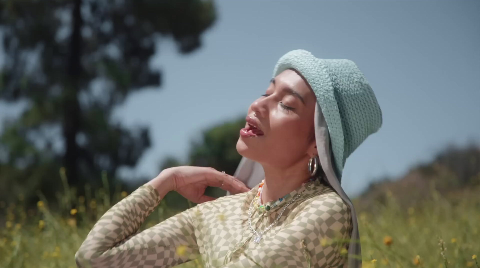 a woman in a hat is standing in a field