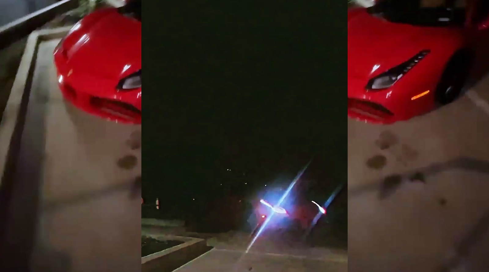 a red sports car driving down a street at night