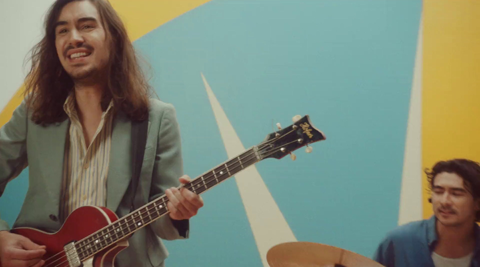 a man with long hair playing a guitar