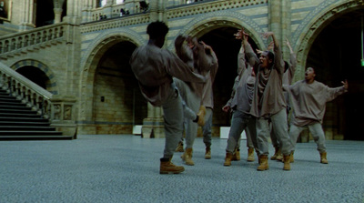 a group of young men dancing in front of a building